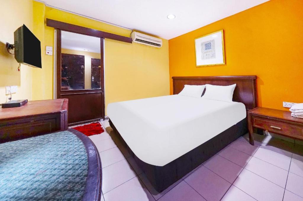 a bedroom with a large white bed and a desk at OYO 90486 New Station Hotel in Klang