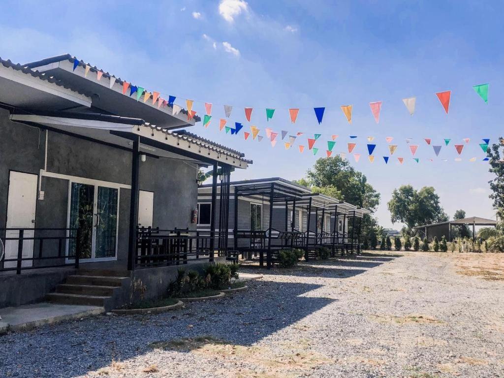 ein Gebäude, an dem bunte Flaggen hängen in der Unterkunft Capital O 75412 V Resort in Ban Wang Ton