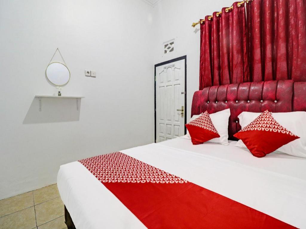 a bedroom with a large bed with red accents at OYO 91886 Bfs Homestay Syariah in Jambi