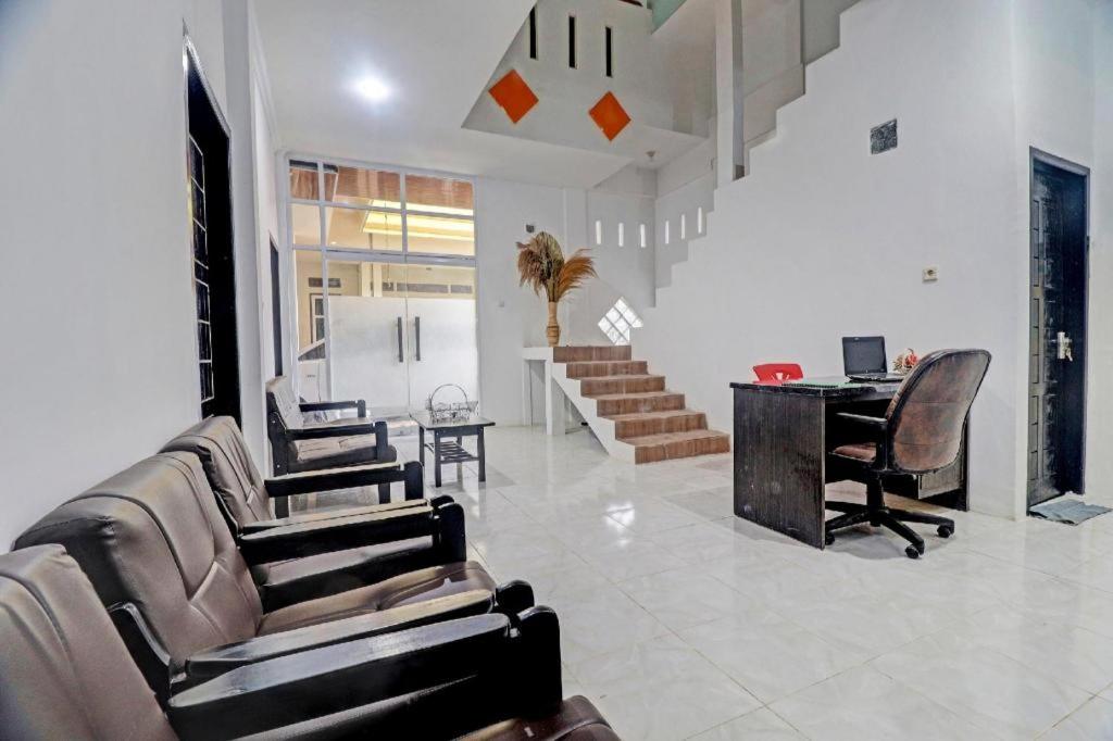 ein Wohnzimmer mit Stühlen und einem Schreibtisch mit einem Computer in der Unterkunft Hotel O Al-razzaq Guest House in Jambi