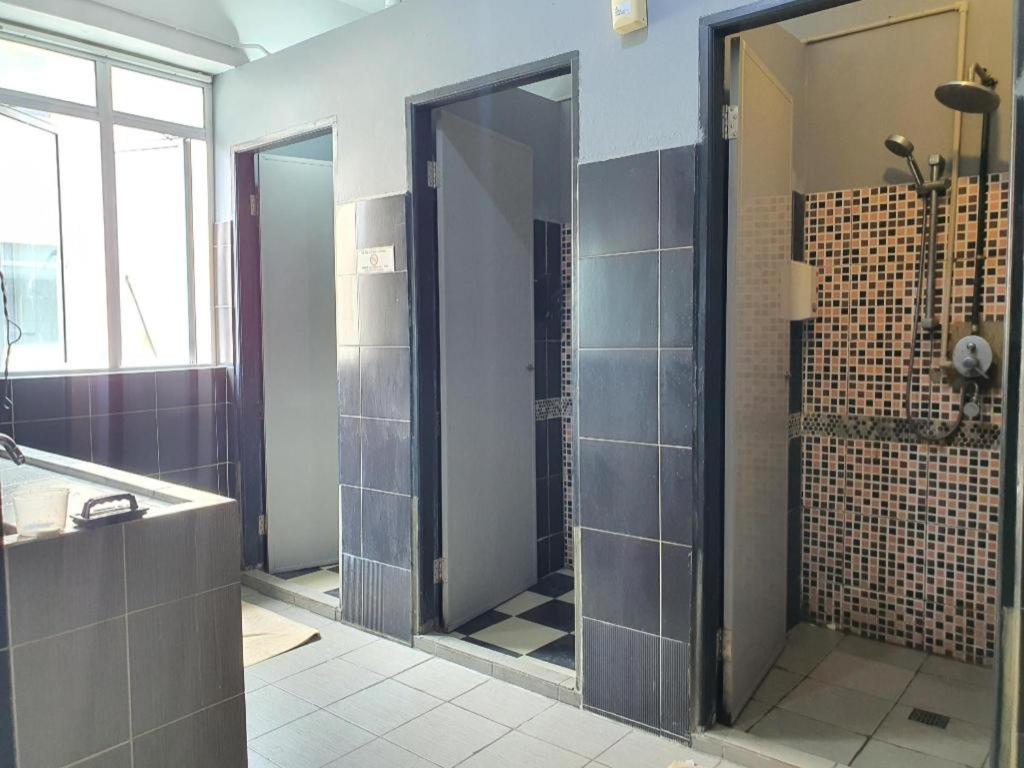 a bathroom with a shower with a large mirror at SPOT ON 90984 Gn Homestay in Miri