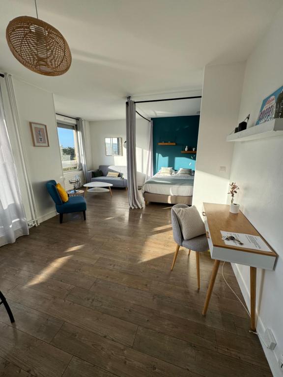 a living room with a room with a bed and a table at Studio- avec parking- proche Cathedrale in Reims
