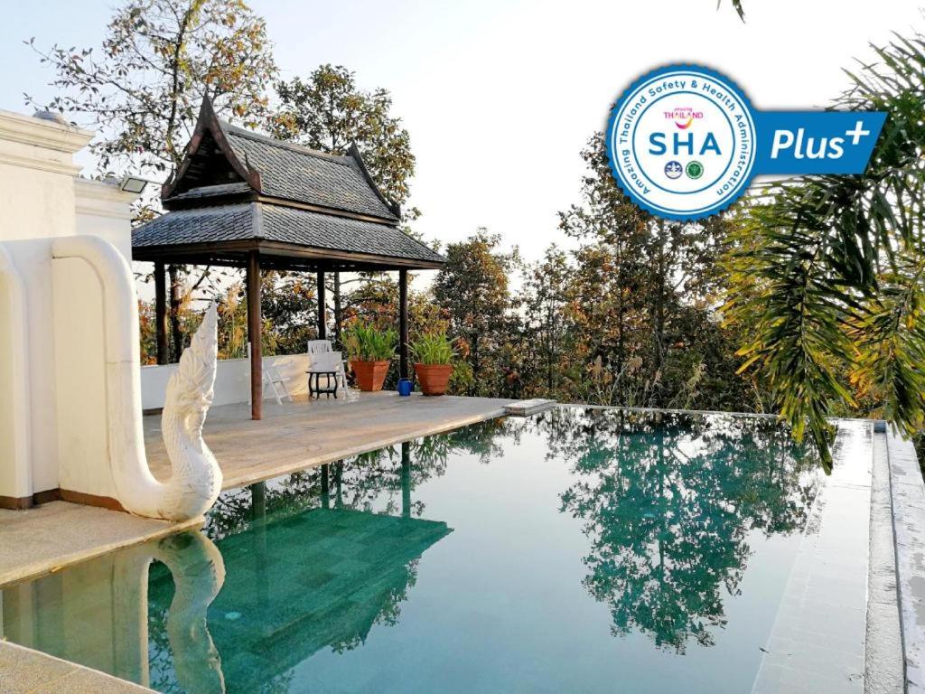 a swimming pool with a gazebo and a swan in the water at Amaravati Wellness Center in Ban Muang Pha