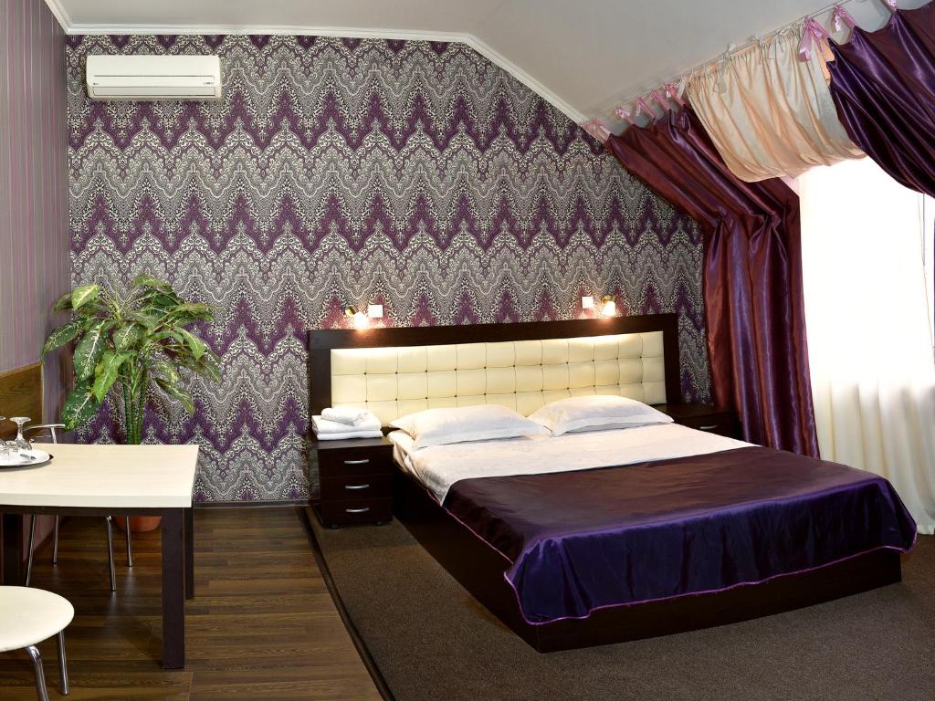 ロストフ・ナ・ドヌにあるRostov Hotelの紫の壁のベッドルーム1室(大型ベッド1台付)