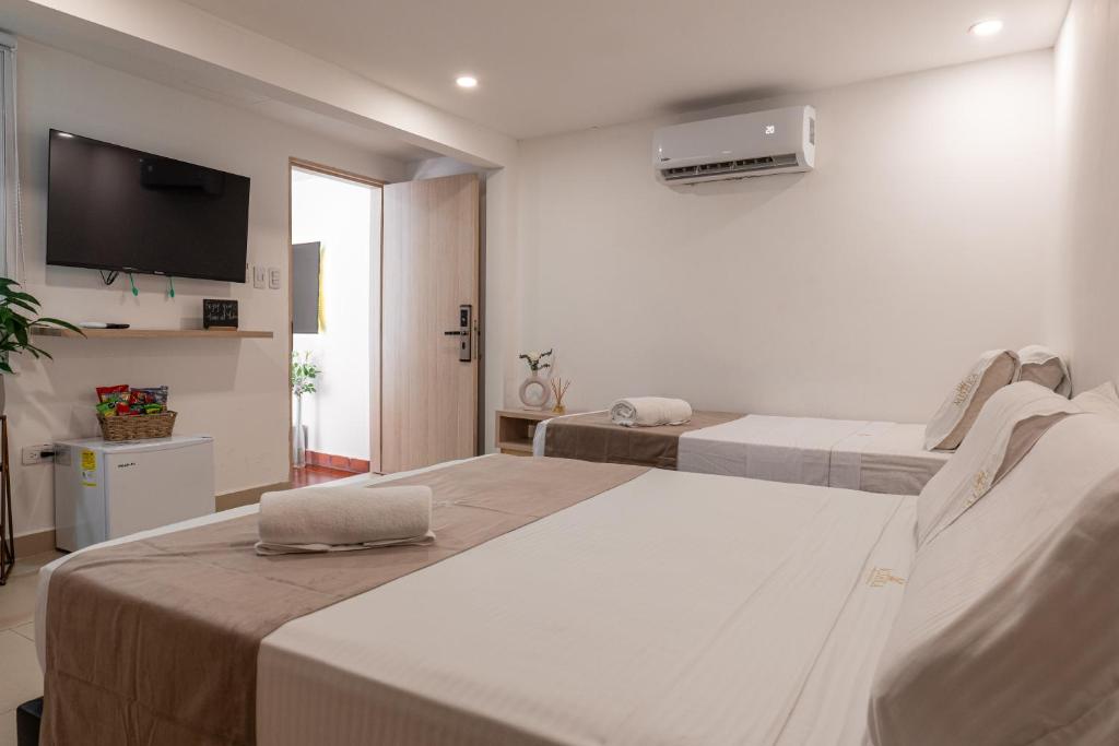 a hotel room with two beds and a flat screen tv at Casa Mishka Hotel Boutique Habitación #105 Nuevo Cartagena in Cartagena de Indias