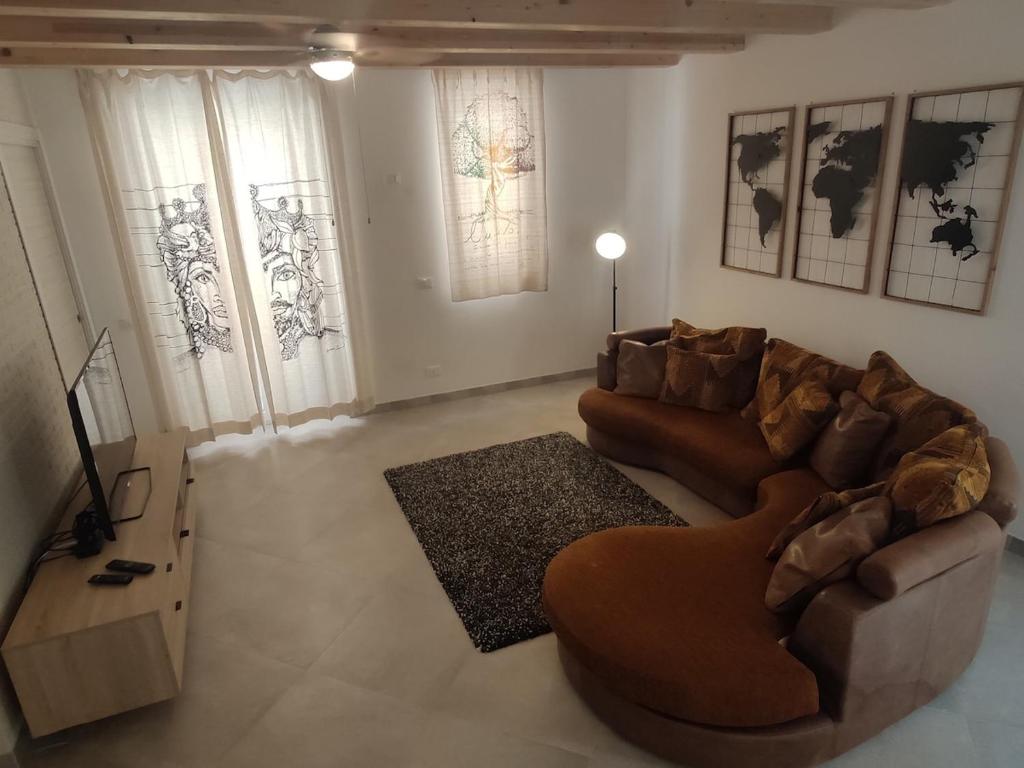 sala de estar con sofá marrón y alfombra en Central modern vacation home in Lascari - Casa Vacanze Luna, en Lascari