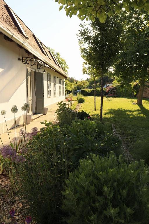 a yard of a house with a lawn and trees at Lelle Cottage in Balatonlelle