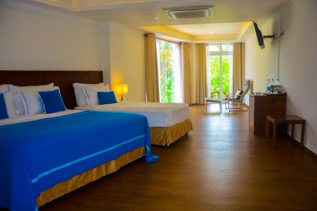 Postel nebo postele na pokoji v ubytování Sayura Beach Hotel