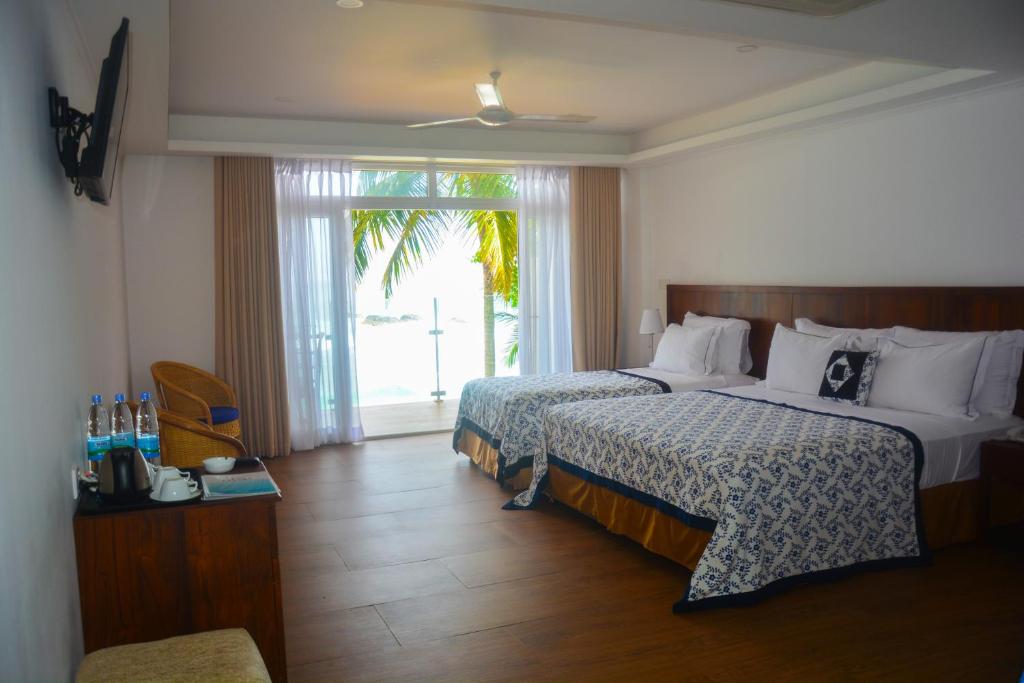 Postel nebo postele na pokoji v ubytování Sayura Beach Hotel