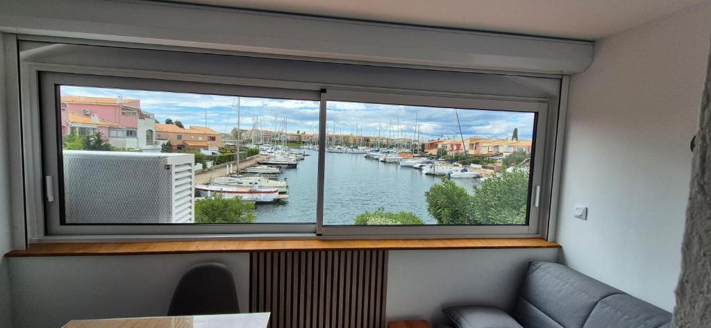 une grande fenêtre avec vue sur le port de plaisance dans l'établissement Studio 6 pers, vue mer, parking, wifi, ponton, au Cap d'Agde