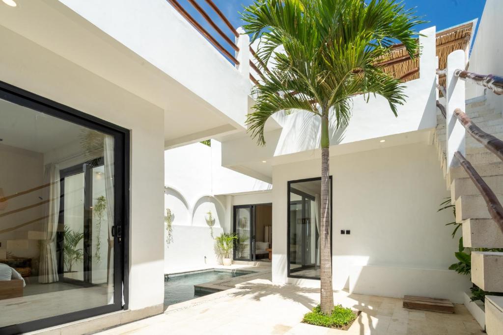 a palm tree in the courtyard of a house at Villa Le Blanc in Tumbak Bayuh