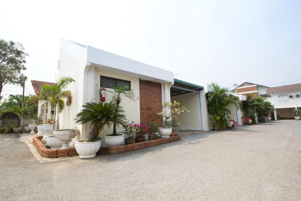 uma casa com vasos de plantas em frente em Bualuang HOTEL em Ang Thong