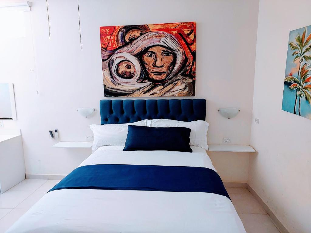 Un dormitorio con una cama con un cuadro en la pared. en Loft 25 excelente y comodo, cerca del vado del rio, consulado,CAS, galerias mall , cama queen , cocineta, en Hermosillo