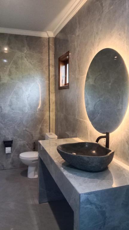 a bathroom with a large sink and a mirror at MMMpulukansurfvilla in Medewi