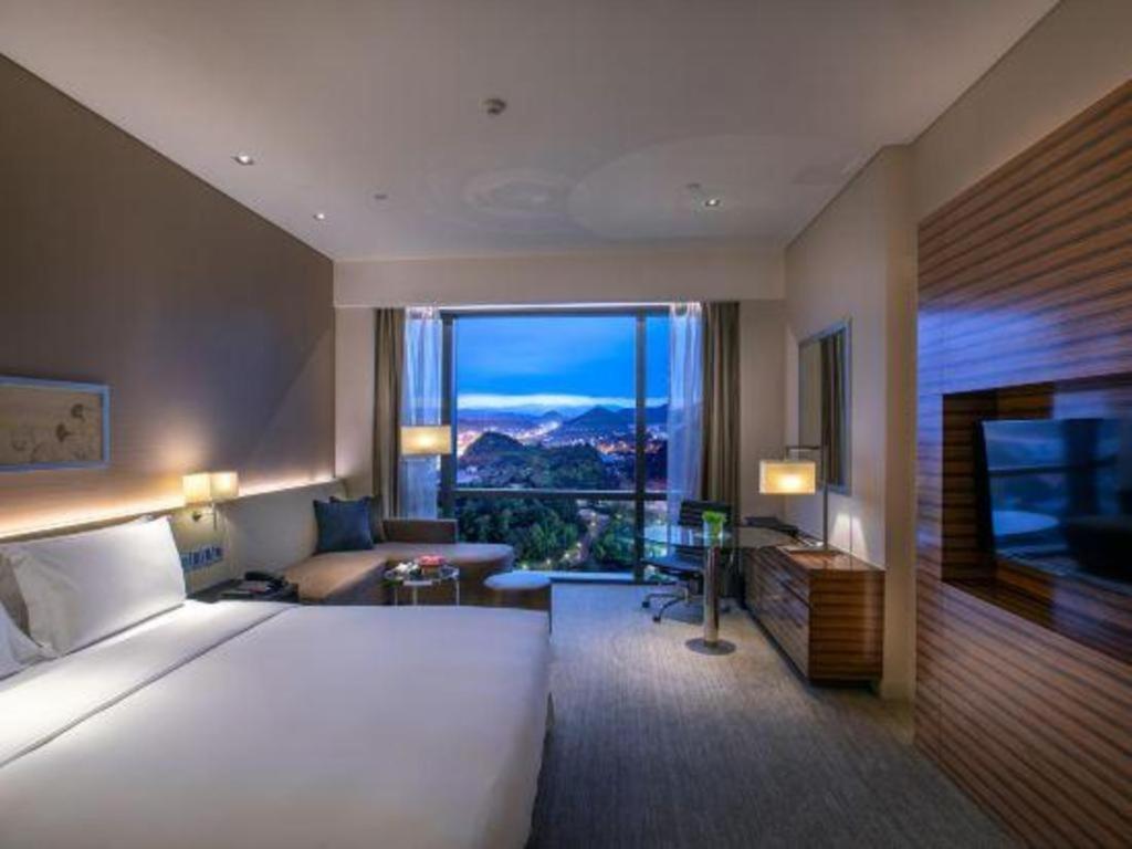 Postel nebo postele na pokoji v ubytování New World Guiyang Hotel