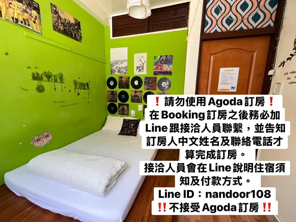 Habitación con cama con pared verde en HouseNandoor, en Tainan