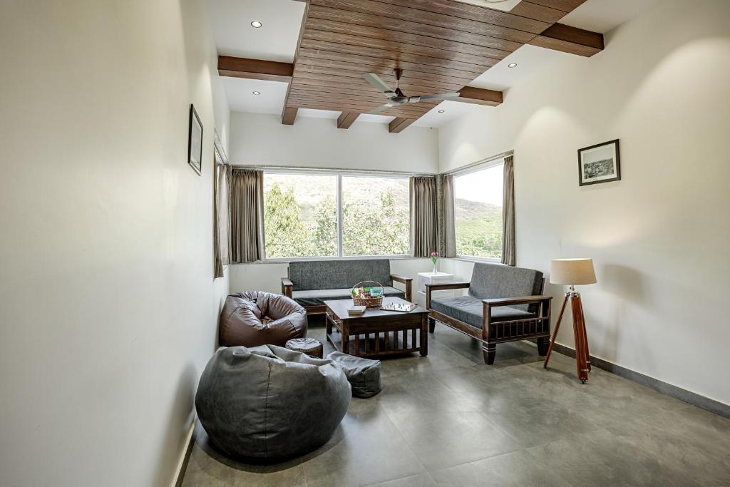 a living room with a couch and a table at Alaya Stays Kodiyat 4-BHK Pet-Friendly Villa With Views of Sajjangarh Palace in Nāi