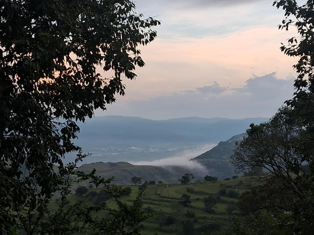 a misty valley with mountains in the distance at villa in Panchgani