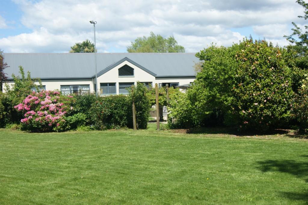 a white house with a lawn in front of it at Waitapu Springs B&B in Takaka