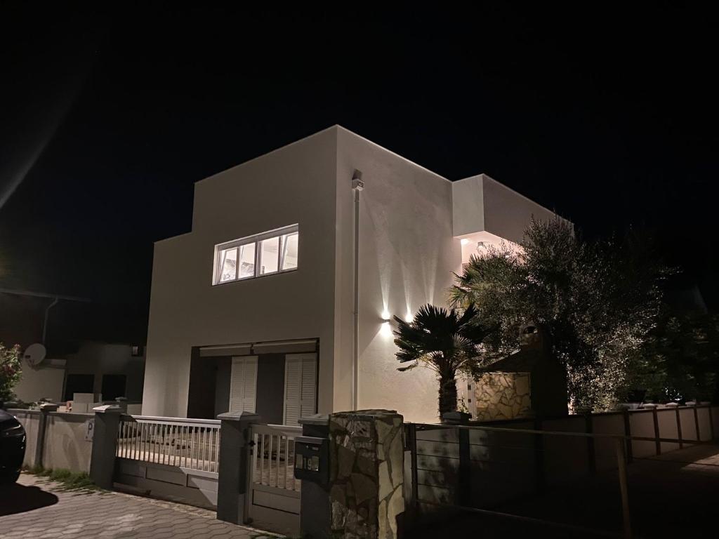 a large white building with a window at night at Apartments Katharina in Batalaži