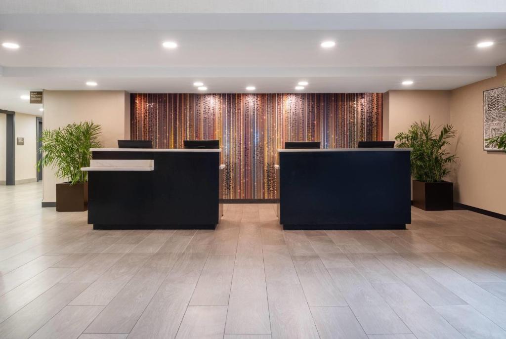 a lobby with desks and potted plants at Wyndham Indianapolis Airport in Indianapolis
