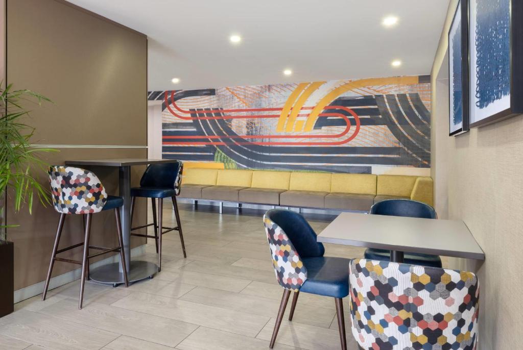 a waiting room with chairs and a couch at Wyndham Indianapolis Airport in Indianapolis