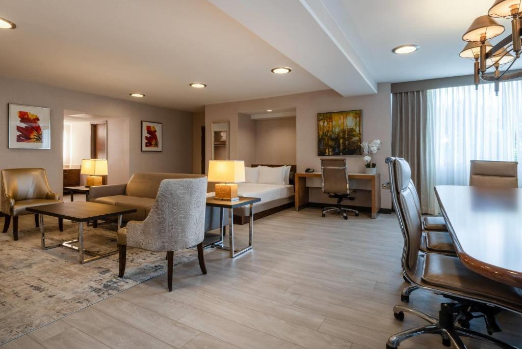 a hotel room with a bed and a table and chairs at Wyndham Indianapolis Airport in Indianapolis