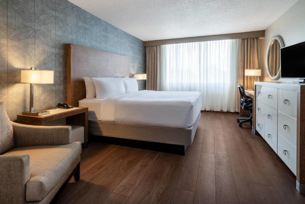 a bedroom with a bed and a desk and a couch at Wyndham Indianapolis Airport in Indianapolis
