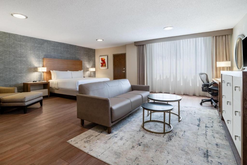 a hotel room with a bed and a couch at Wyndham Indianapolis Airport in Indianapolis