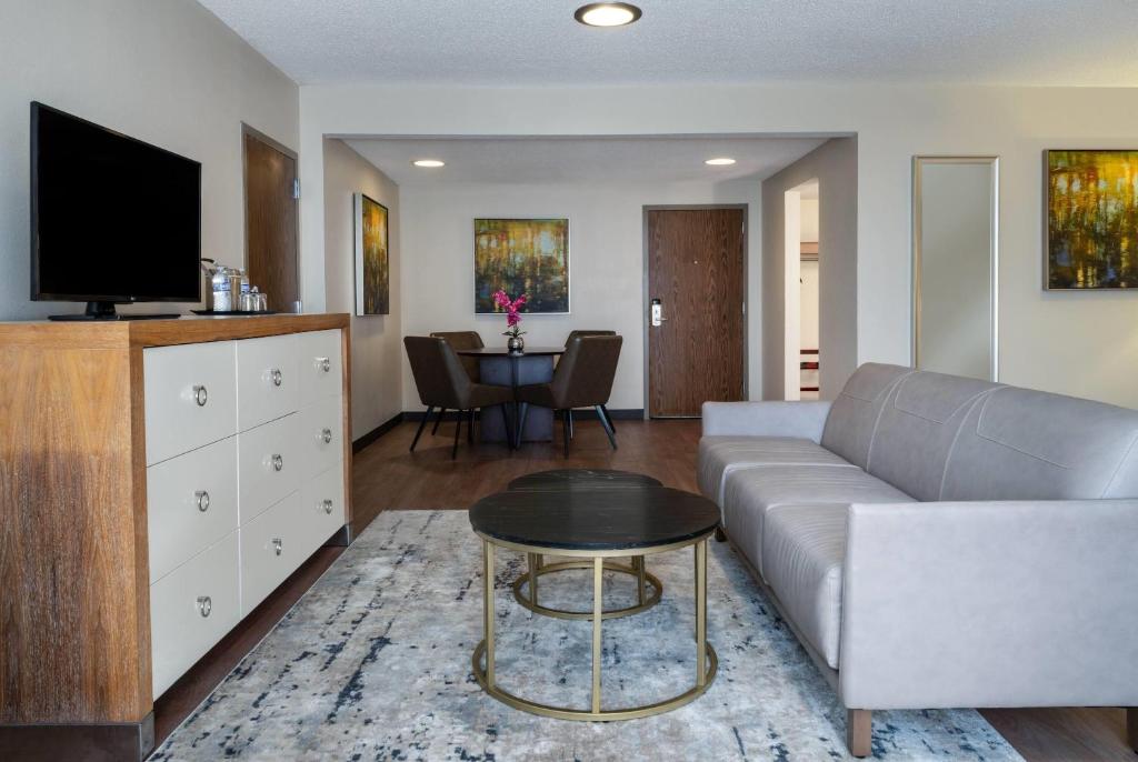 a living room with a couch and a table at Wyndham Indianapolis Airport in Indianapolis
