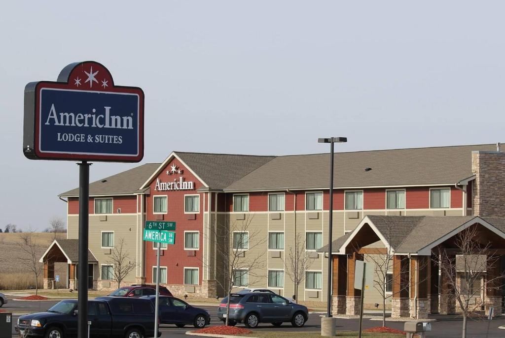 un cartel frente a un edificio con hotel en AmericInn by Wyndham Cedar Rapids Airport, en Cedar Rapids