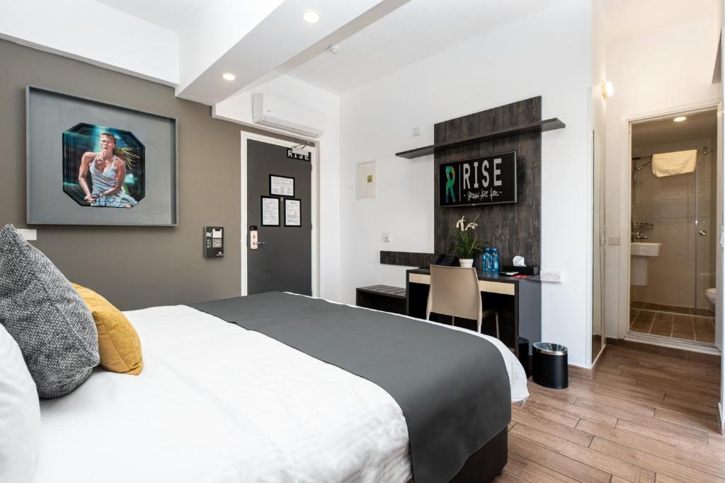a bedroom with a bed and a desk and a bathroom at Rise Urban Art Hotel in Larnaca