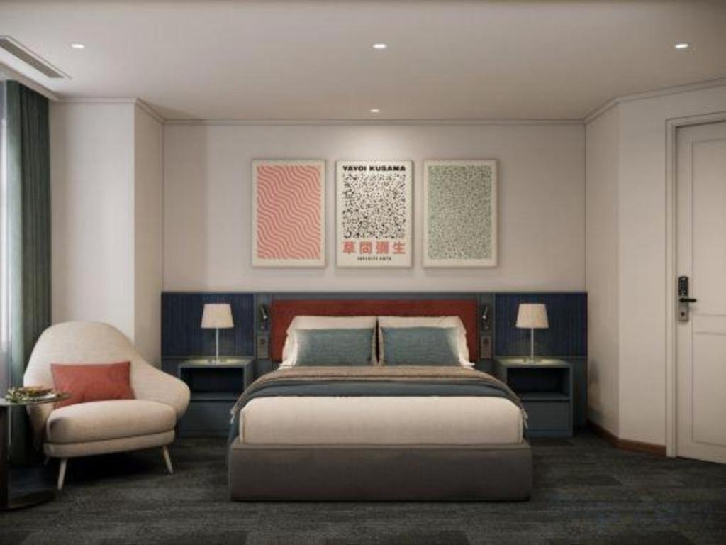 a bedroom with a bed and a chair at Lenid Hotel Tho Nhuom in Hanoi