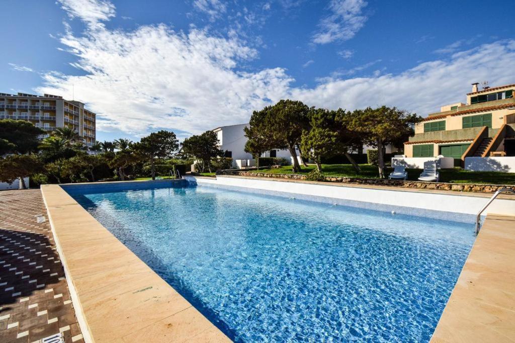 a large swimming pool with blue water at Apartamento Calan Forcat in Ciutadella
