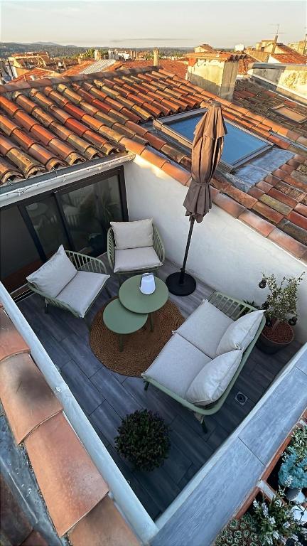 une terrasse en bois avec une table et un parasol dans l'établissement DUPLEX MIRABEAU - Roof terrace with panoramic view, à Aix-en-Provence