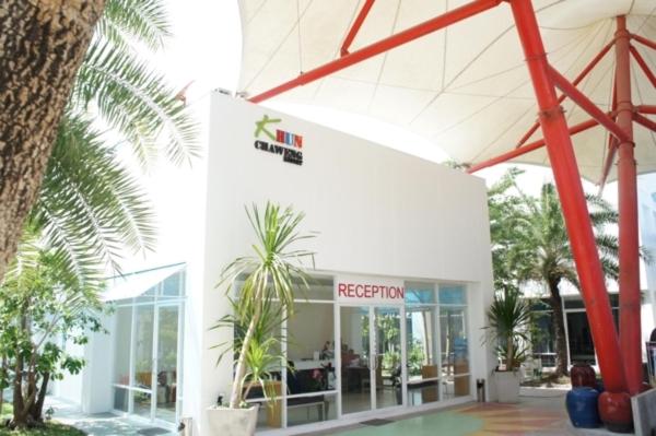 a white building with palm trees in front of it at Khun Chaweng Resort in Chaweng