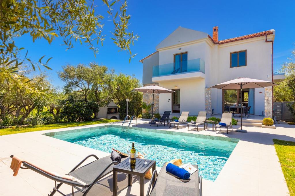 a villa with a swimming pool and a house at Villa Nineta in Tavronitis