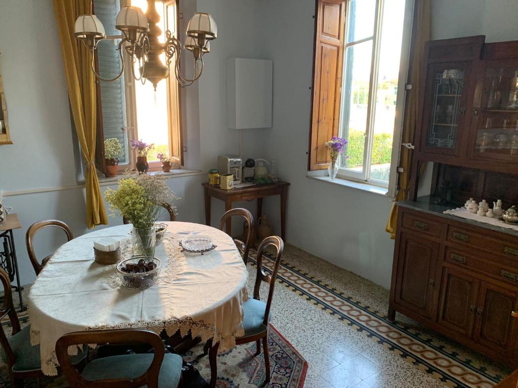 a dining room with a table and chairs and a kitchen at Bed and Breakfast Villa Adelina in Lucca
