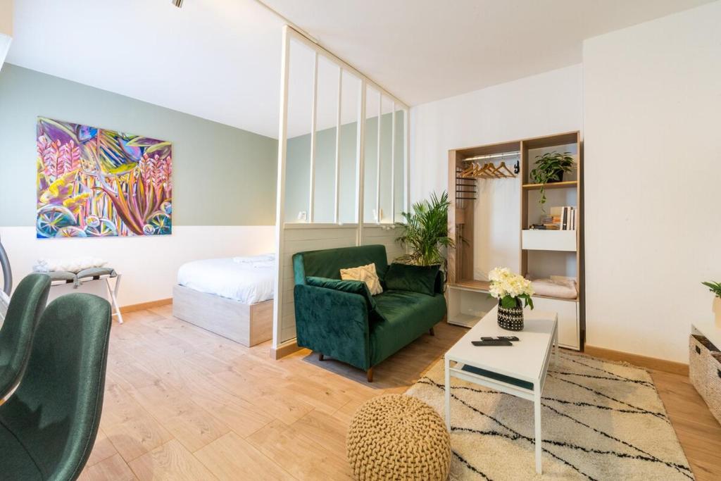 ein Wohnzimmer mit einer grünen Couch und einem Bett in der Unterkunft Very nice apartment in Mulhouse Lambert city center in Mulhouse