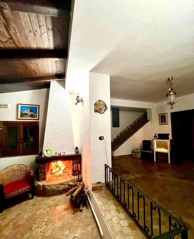 a living room with a fireplace and a staircase at Villa Taormina Sicily in Furci Siculo