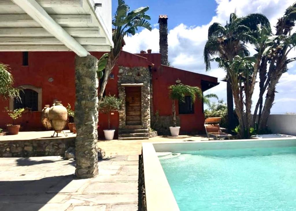 a house with a swimming pool in front of a house at Villa Taormina Sicily in Furci Siculo