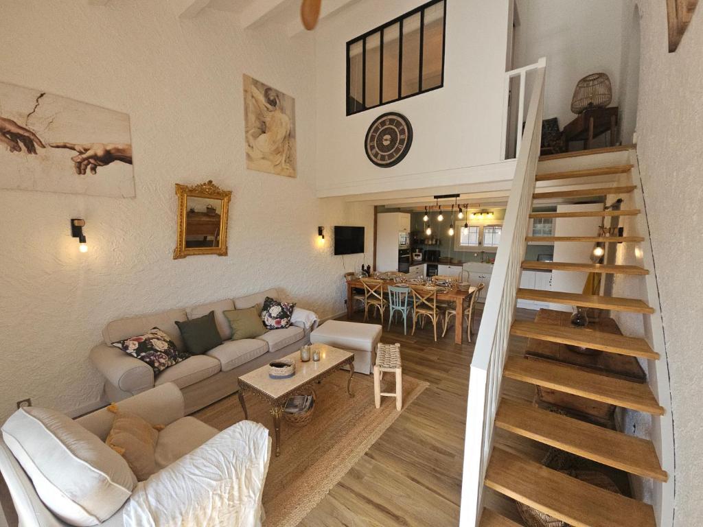 een woonkamer met een bank en een trap bij Maison 3 chambres - Central - Proche du lac in Esparron-de-Verdon
