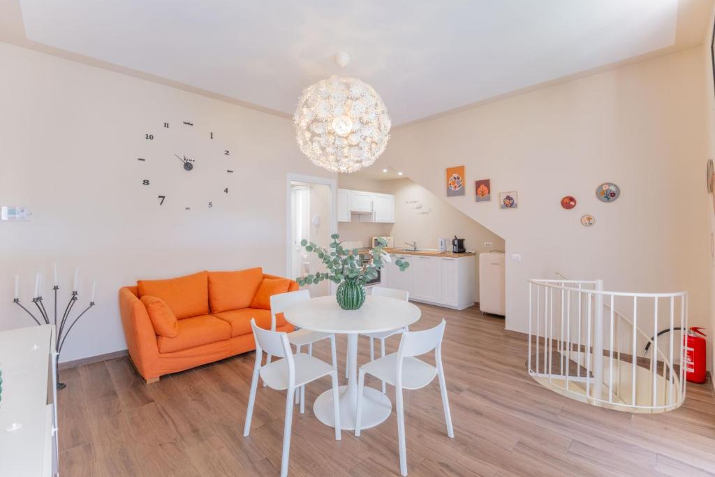 a living room with a table and an orange couch at Casa Margherita tra charme e verde Malpensa self-check-in in Casorate Sempione