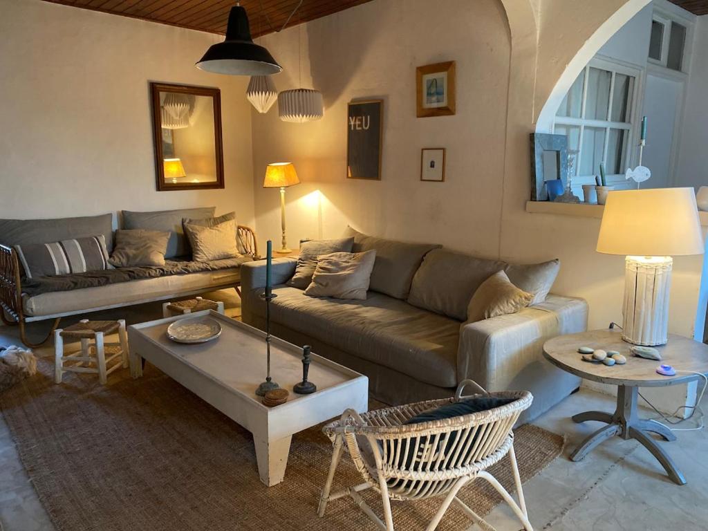 un salon avec un canapé et une table dans l'établissement Ancienne maison de pêcheur, à L'Ile d'Yeu
