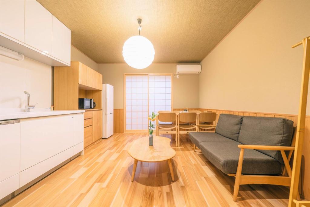 a kitchen and a living room with a couch and a table at Miro Sanjo Saiin Tei in Kyoto