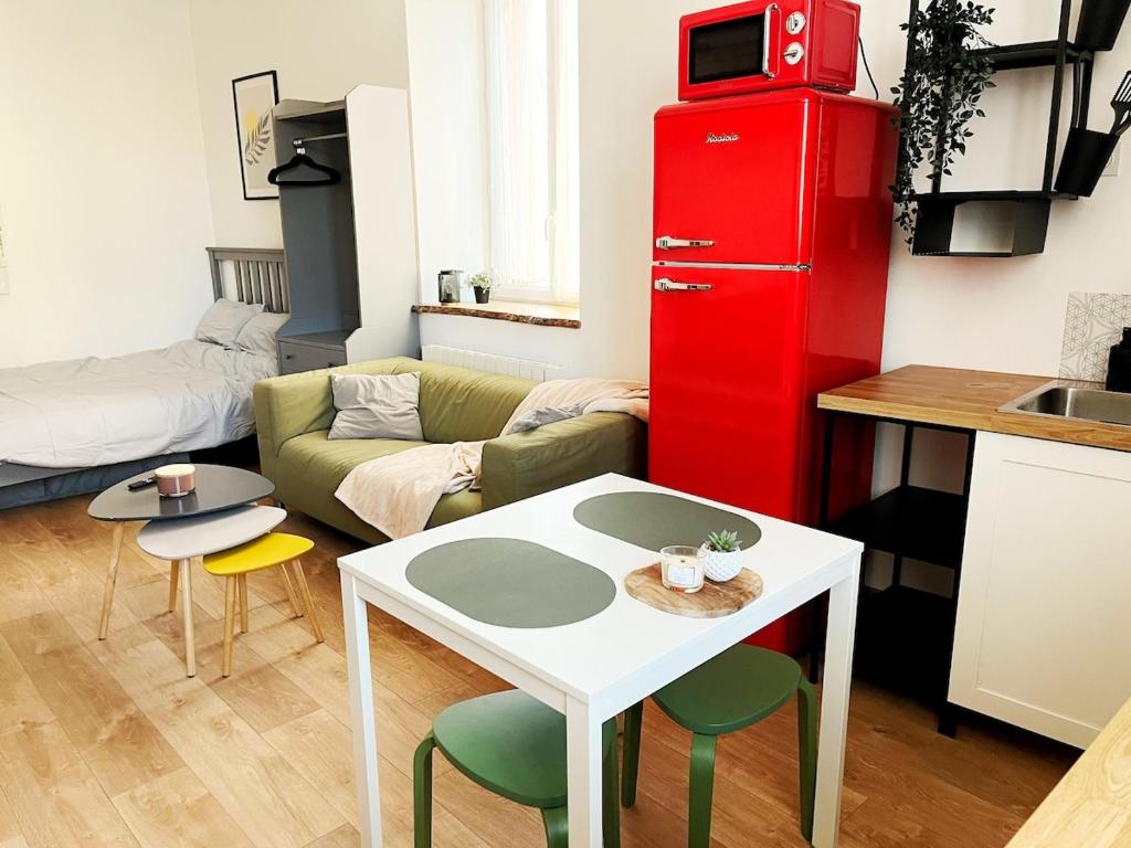 een woonkamer met een keuken en een rode kast bij Studio Chic au Style Rétro Moderne in Saint-Genix-sur-Guiers