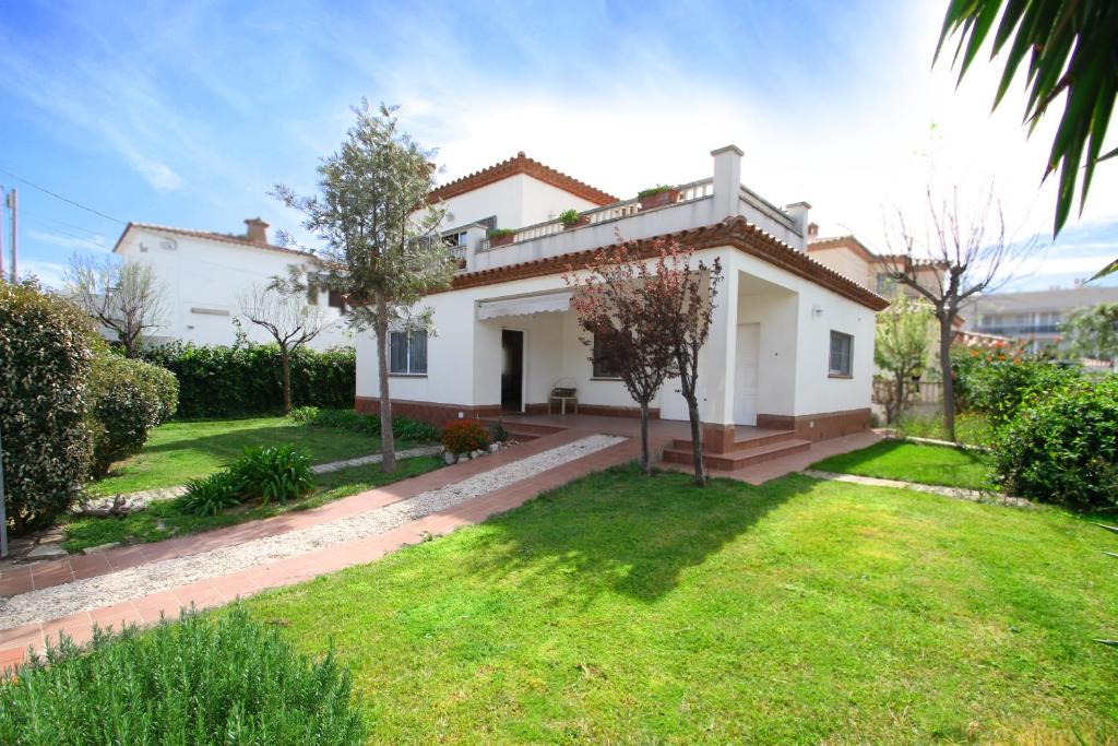 una casa blanca con césped delante en ARENDA Villa Rivera, en Miami Platja