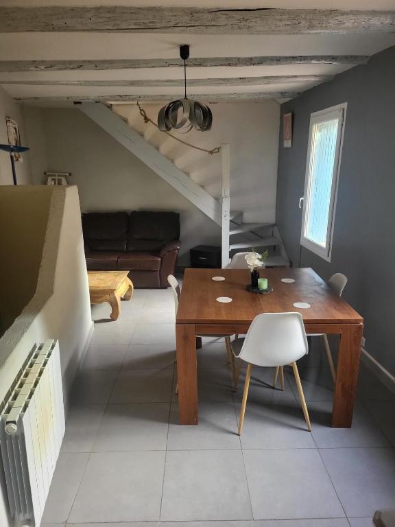 un salon avec une table en bois et un canapé dans l'établissement Charmante maison de village, à Saint-Paul-les-Fonts