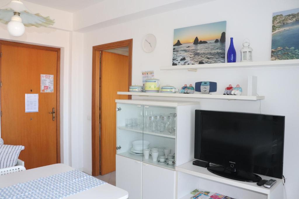 salon z telewizorem na białej półce w obiekcie La Joya Sileno Beach w mieście Giardini Naxos