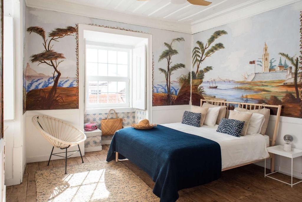 a bedroom with a bed with a painting on the wall at Central Ericeira Apartment with Lift in Ericeira